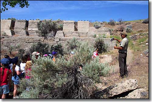 A ranger leading a group of visitors past the Rock Point Mill foundations at Dayton State Park