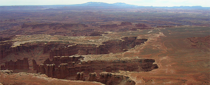 A view of red rock canyon walls and open desert from Grand View Point
