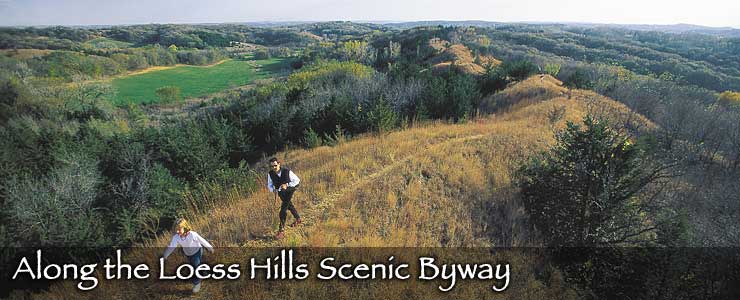 People hiking along a ridge above trees and meadows along the Loess Hills Scenic Byway