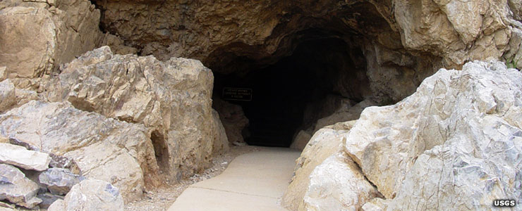 A concrete sidewalk extends down into the natural entrance to Mitchell Cavern