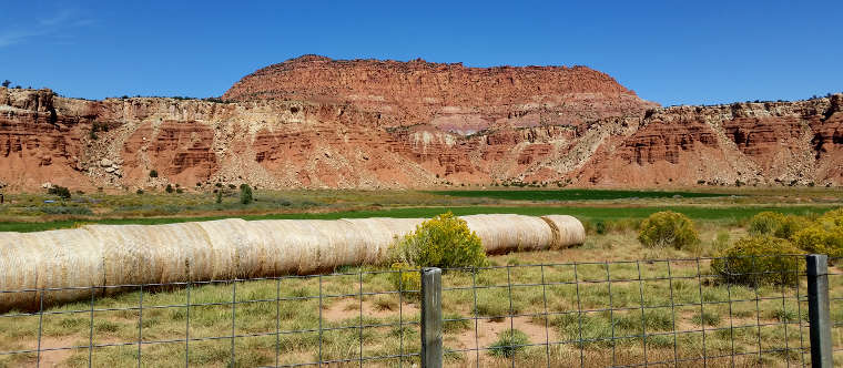 A view of red rocks, buttes and hay bales between Bicknell and Torrey