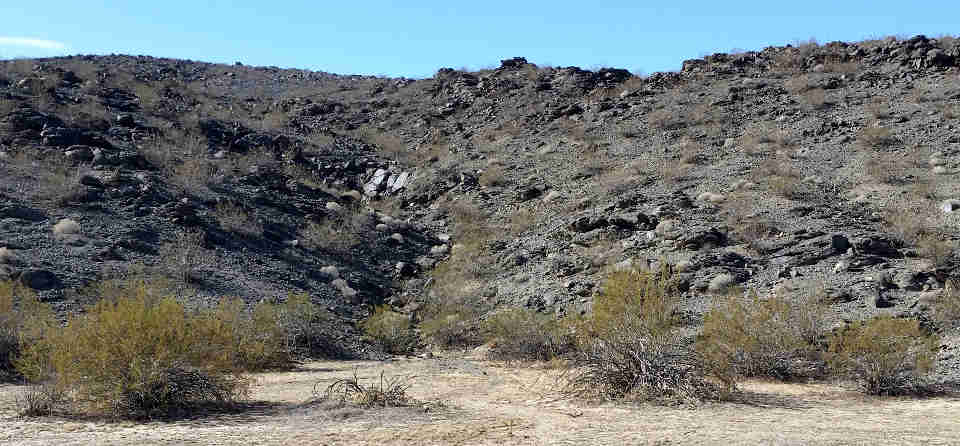 Sharp mountains, sand and cactus: typical Mohave desert landscape along Route 62