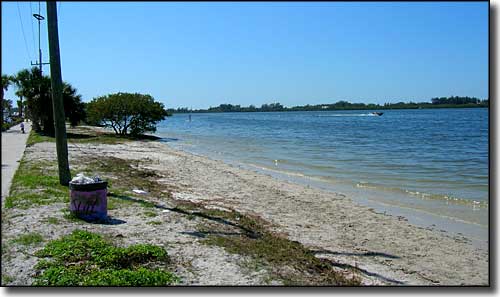 Sidewalk, a bit of grass and beach along thePalma Sola Scenic Highway