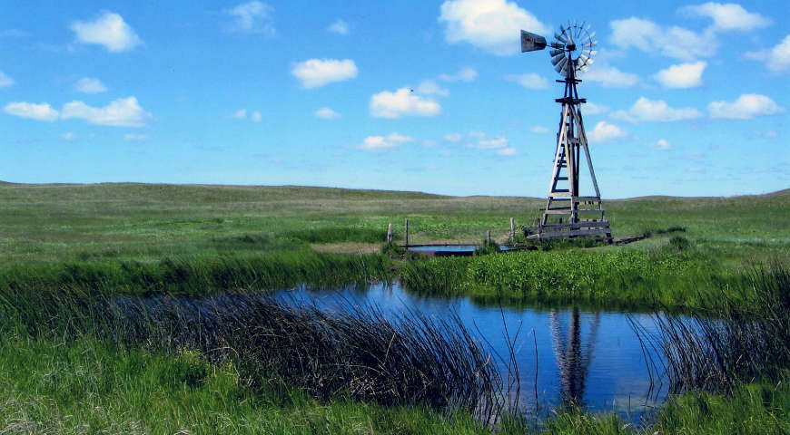 A windmill above a pond along the Sandhills Journey