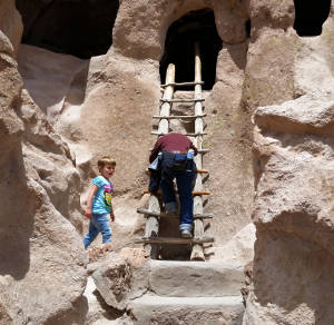 Climbing a ladder into one of the cliff dwellings at Bandelier National Monument