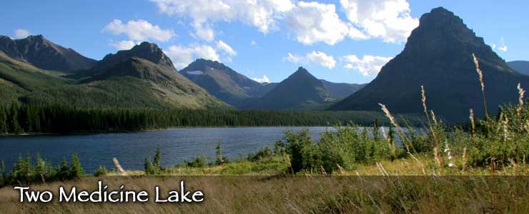 Two Medicine Lake, surrounded by forest with a mountainous backdrop