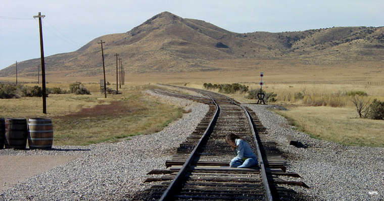 Someone inspecting the golden spike marker at the Golden Spike National Historic Site Golden Spike National Historic Site