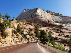 Motorcycles below multicolored cliffs