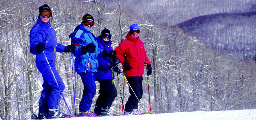 Downhill skiers standing on a slope in the snow